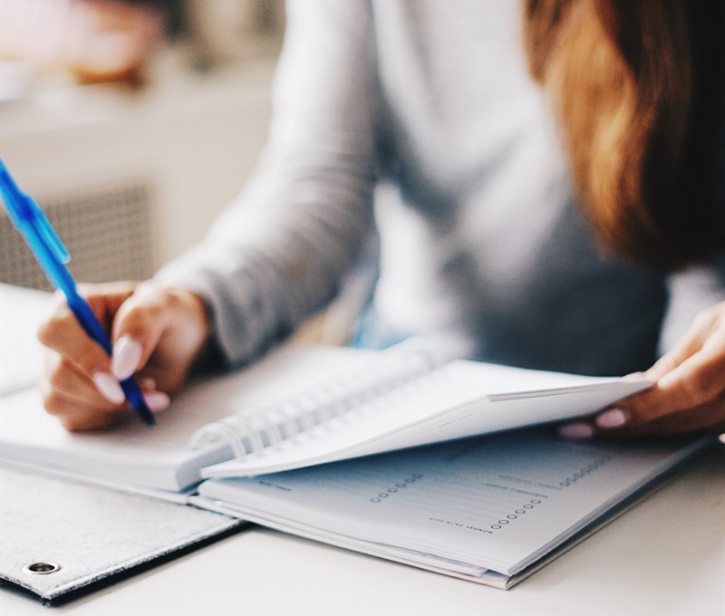 Someone working through notes in a planner