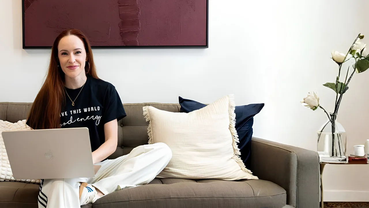 Casey working from a laptop on a sofa