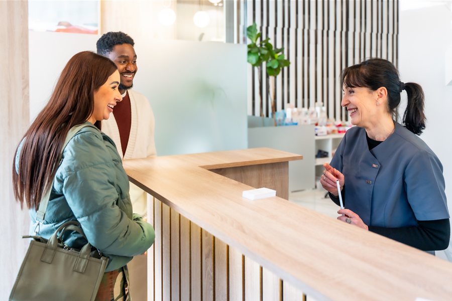 Patients being greeted at a practice front desk
