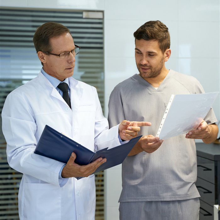 A doctor and a team member reviewing paperwork together